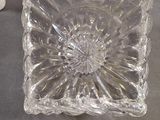 a clear glass bowl sitting on a table next to a cup