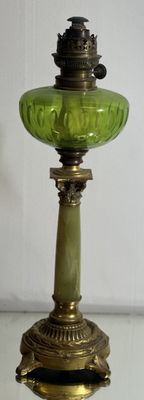 a green glass lamp that is sitting on a glass table