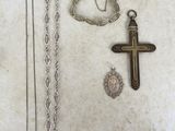 une croix, un collier et un bracelet posés sur une table