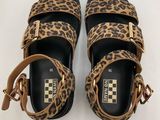 a pair of leopard print sandals on a white background