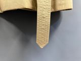 un gros plan sur une veste beige suspendue à un cintre