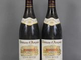 two bottles of wine sitting on top of a table next to each other