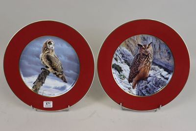 paire d'assiettes rouges et dorées ornées de chouettes sur fond blanc