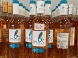 bottles of rose wine are lined up on a shelf in a store