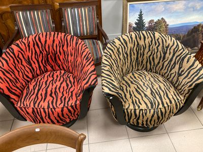 two zebra print chairs in a room with a painting on the wall