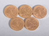 six british pound coins sitting on top of each other on a white surface