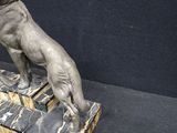 a statue of a dog sitting on a marble block