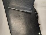 two black leather notebooks sitting on top of a white table