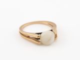 un gros plan d'une bague en or sertie d'une pierre blanche