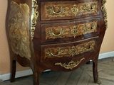 a small chest of drawers with a marble top