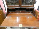 a wooden desk with a glass top and two drawers