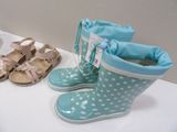 two pairs of rain boots and a pair of sandals on a table