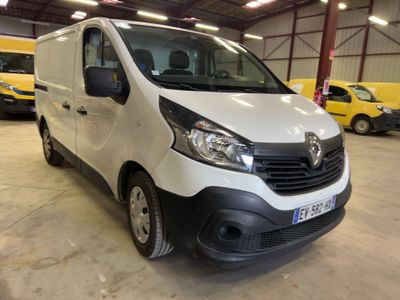 La camionnette blanche est garée dans un grand entrepôt, à côté d'autres véhicules.