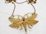 un gros plan d'un collier orné d'un papillon