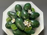 cucumbers in a white bowl with green leaves and flowers