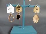 a display of earrings on a stand with price tags on it