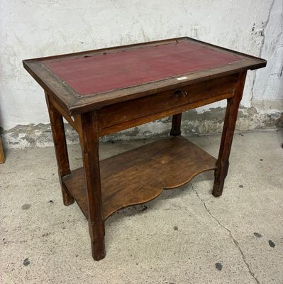 une petite table en bois avec un plateau rouge posée sur un trottoir