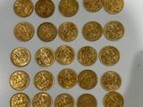 some of the gold coins have been placed on a white surface