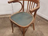 une chaise en bois avec une assise verte dans une pièce