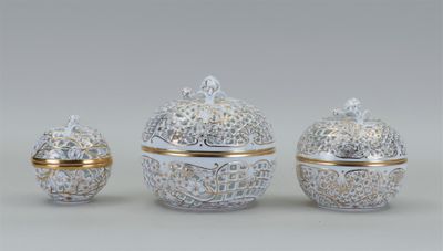quatre objets en porcelaine décorés d'argent et d'or sur un fond gris