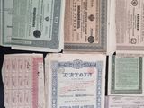 several old certificates are stacked on top of each other on a table
