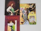 trois livres sont posés les uns à côté des autres sur une surface blanche