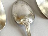 several silver spoons and spoon spoons on a white surface
