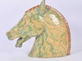 a green and yellow horse head statue on a white background