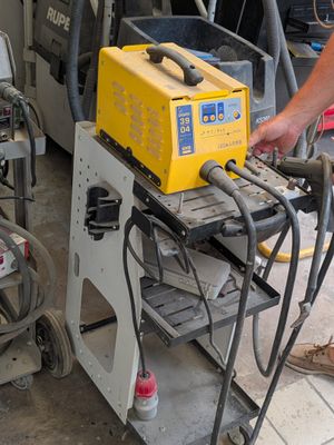 un homme qui travaille sur une machine dans le garage