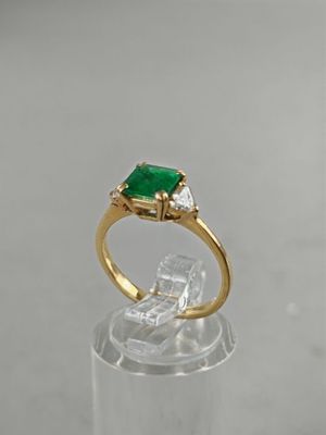 a close up of a ring with a green stone on top of it