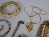 a lot of gold jewelry on a white table