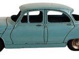 une petite voiture bleue posée sur une surface blanche