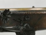 a metal bowl with a bird on it on a stand