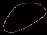 a gold necklace with a chain that has been set on a black background