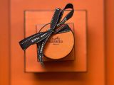 une boîte orange surmontée d'un ruban noir