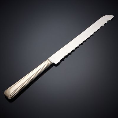 a close up of a knife on a table with a black background
