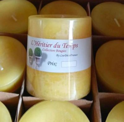 des bougies dans une boîte, munies d'étiquettes, posées sur une table