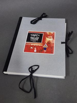une photo d'un livre posé sur une table, à côté de ciseaux