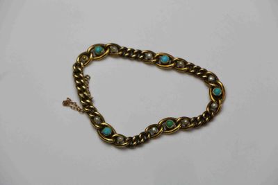 un gros plan sur un bracelet en or orné de pierres de turquoise