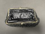 a close up of a black purse on a table