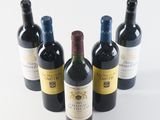 six bottles of wine are lined up in a row on a white surface