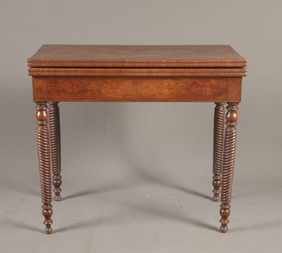 une petite table en bois avec des pieds tournés et un plateau en bois