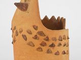un vase marron orné d'un oiseau sur un fond blanc