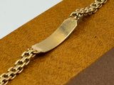 gold plated bracelet on a wooden box on a white background