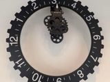 une horloge accrochée au mur au-dessus d'un lavabo dans une salle de bains