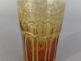 a glass cup with a gold design on it