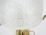 an old fashioned lamp with a glass shade on a metal stand