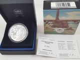 une pièce d'argent dans une boîte, accompagnée d'un ticket correspondant