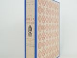 un vieux livre posé sur une table blanche à côté d'un mur blanc