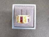 bague en or jaune sertie de pierres multicolores, présentée dans un coffret cadeau